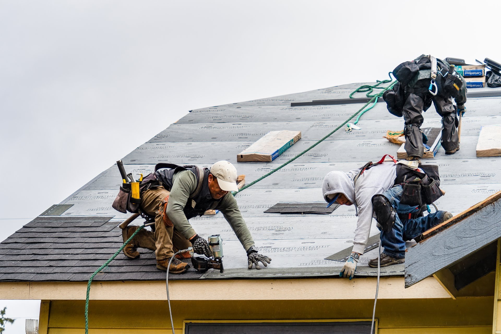 Professional roofing crew installing shingles